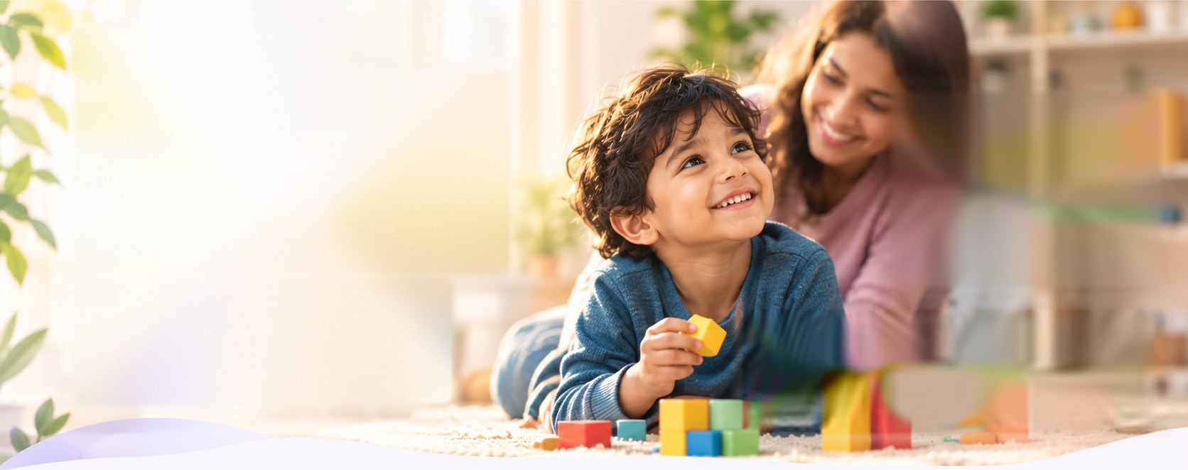A smiling child playing with colourful wooden blocks while a parent watches beside them